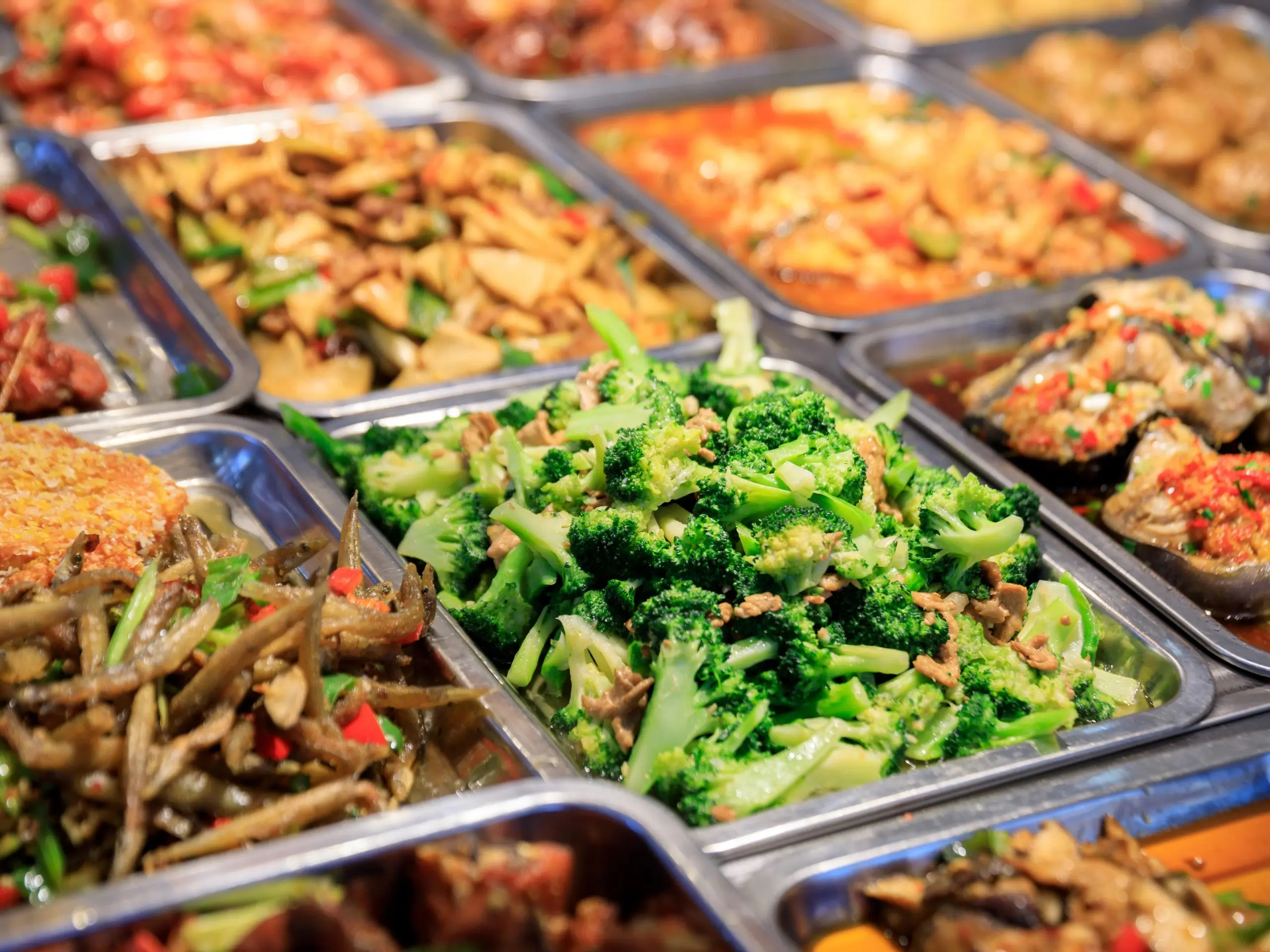 Fresh vegetable dishes and savory entrees in buffet trays at Buffet City, a Buffet Restaurant in Tuscaloosa